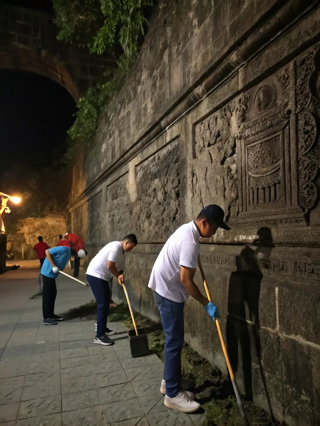 A vibrant photo showcasing volunteers cleaning up a historical site in Petit-Canal, focusing on community involvement in heritage preservation.